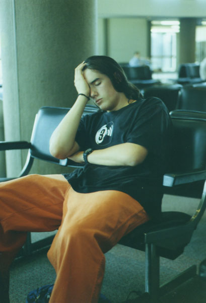 z_chris_asleep_airport_orangepants